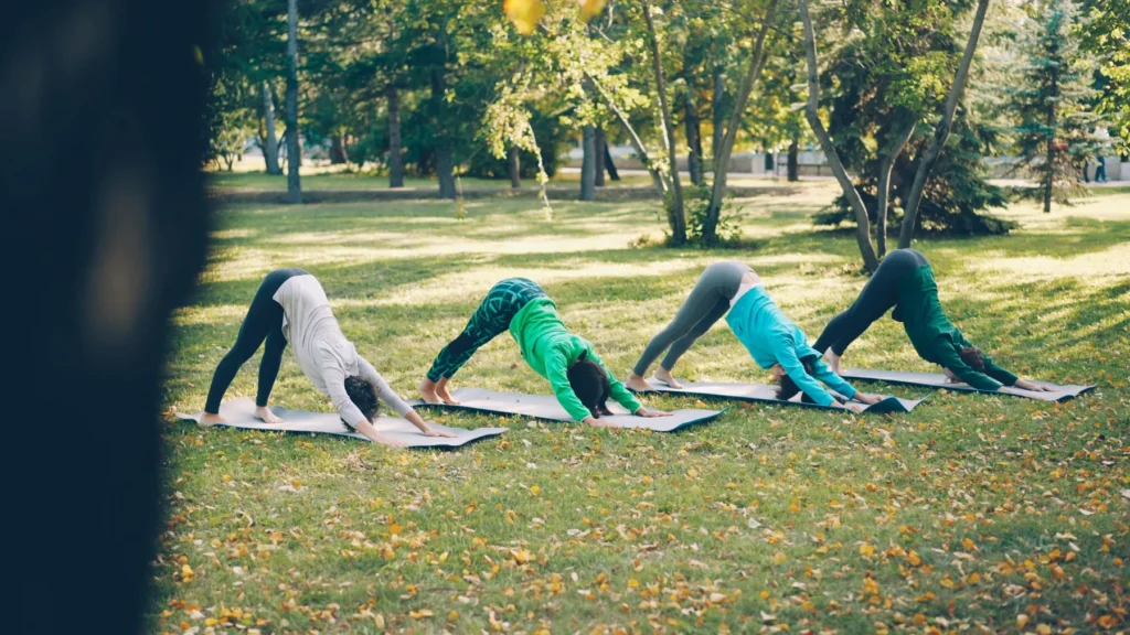 Quatre personnes qui pratiquent le yoga ensemble dans un parc