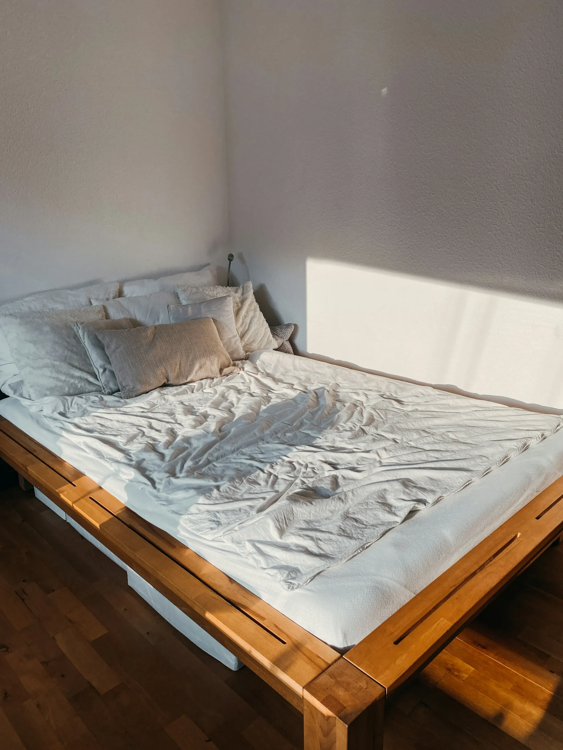 Lit aux draps clairs baigné de lumière du matin